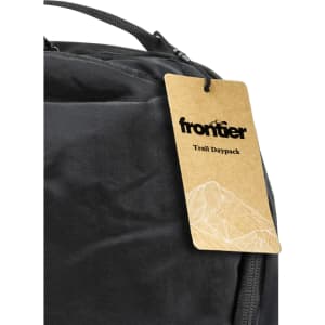 A black daypack with a tag attached, featuring a simple mountain graphic and a logo.