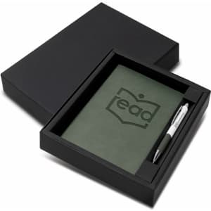 A green notebook and silver pen set in a black gift box, featuring a logo on the notebook.