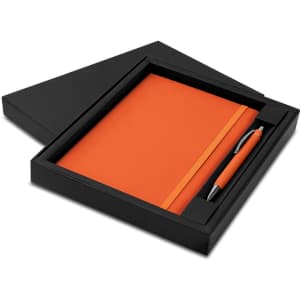 An orange notebook and pen set in a black box with a logo.