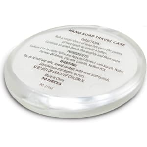 A round, clear travel case containing hand soap ingredients, with a smooth surface and a subtle sheen.