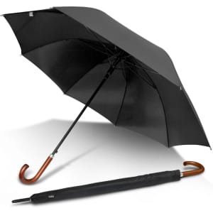 A black executive umbrella with a curved wooden handle, partially opened, alongside its folding cover.