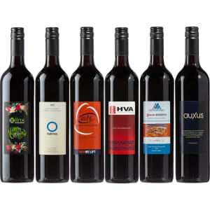 A collection of six red wine bottles with varying designs and labels, featuring dark red glass and colourful branding.