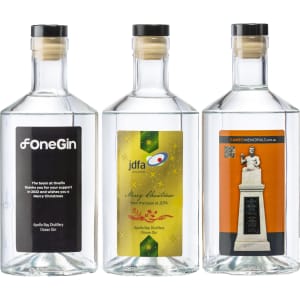 Three clear glass bottles of Apollo Bay Distillery Ocean Gin, featuring various labels and a cork stopper.