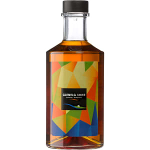 A drink bottle of whisky with a vibrant geometric label design featuring colours like orange, green, and blue.