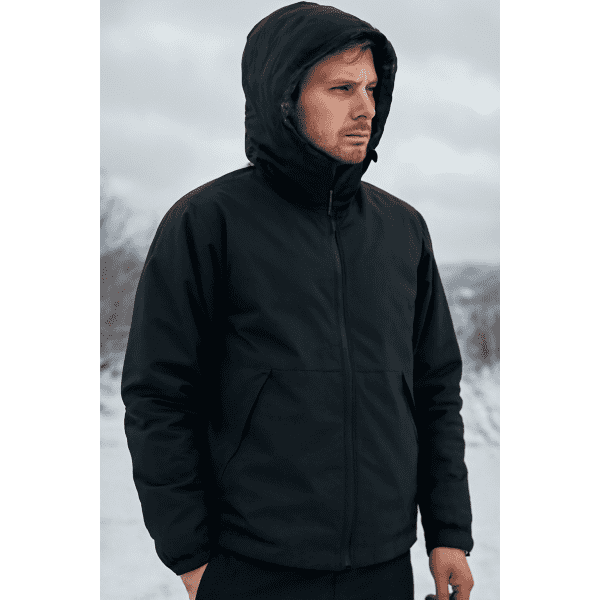 A black tech jacket with a hood is worn by a person standing outdoors in a snowy landscape.