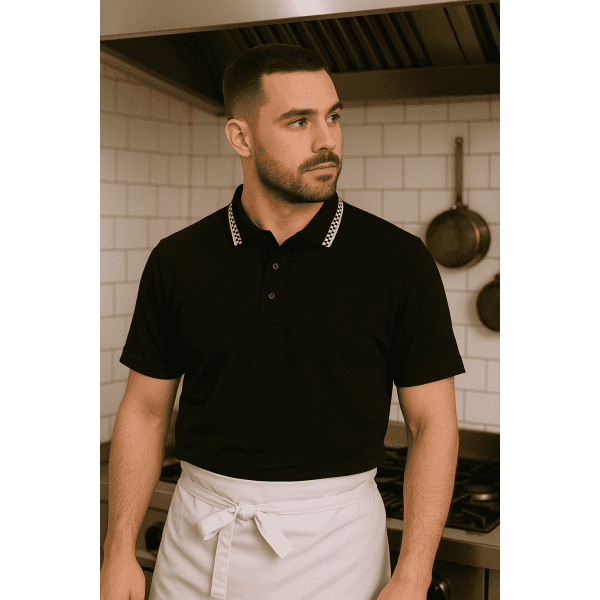 A black and white chef polo with a collar, featured on a person in a kitchen setting.