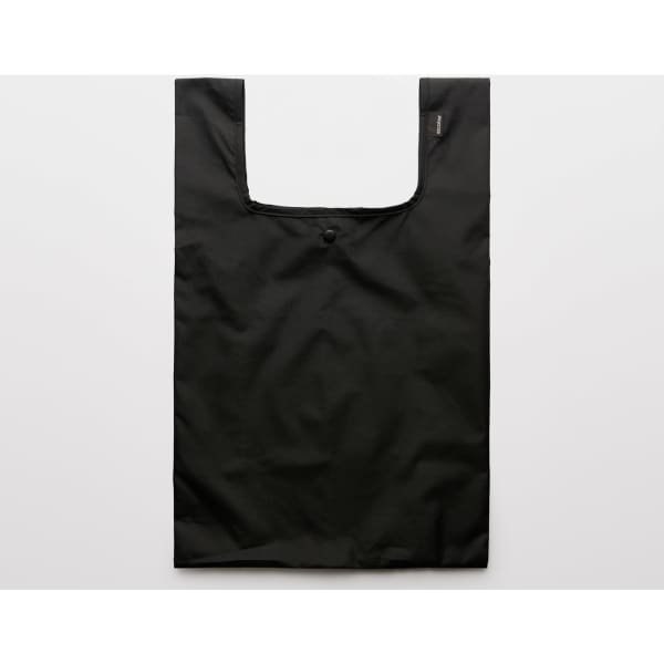 A reusable grocery bag in solid black with a circular button closure and a logo.