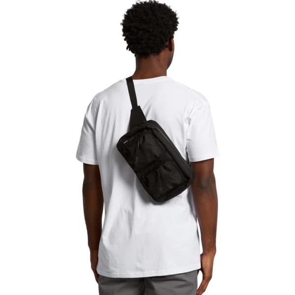 A person wearing a black recycled double waist bag slung over their shoulder, against a plain background.