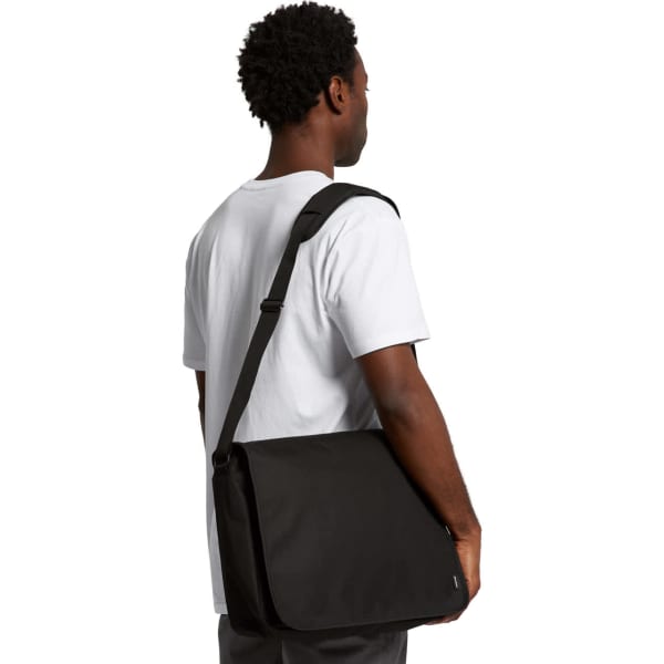 A black recycled messenger bag is being held by a person wearing a white t-shirt. The bag features a shoulder strap and a logo.