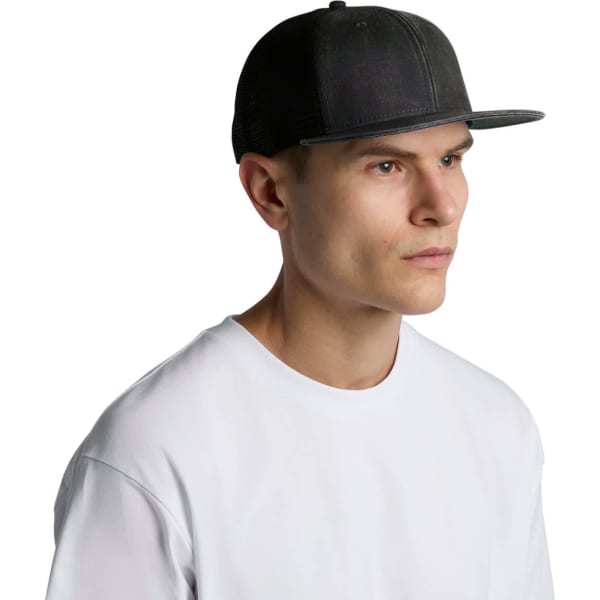 A faded black trucker cap with a structured front and mesh back, worn by a model in a white shirt.