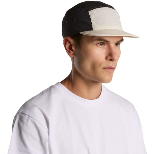 A two-tone nylon cap in black and cream, featuring a curved brim and a logo on the side.
