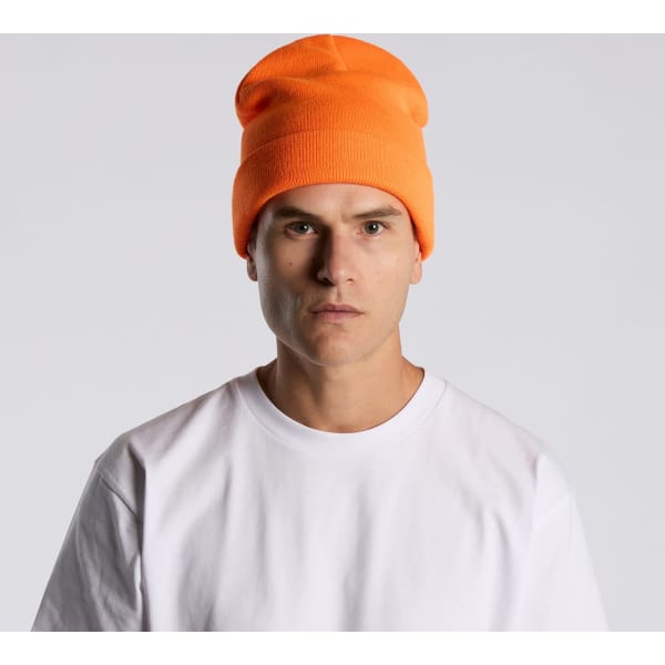 An orange beanie worn by a model, featuring a fitted design and a casual style.