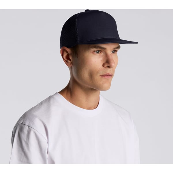 A navy trucker cap with a flat brim, featuring a logo, worn by a model in a white T-shirt.