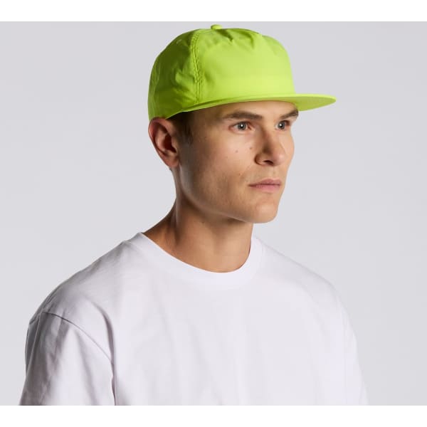 A bright yellow cap on a model, featuring a flat brim and a fitted design. The cap includes a logo.