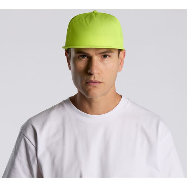 A bright yellow cap with a flat brim, worn by a person in a white t-shirt. The cap features a logo.