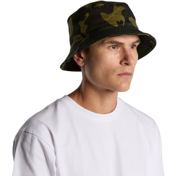 A camouflage bucket hat in green tones, featuring a branding logo, worn by a person facing to the side.