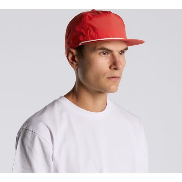A red cap with a flat brim, featuring a logo and worn by a model against a neutral background.