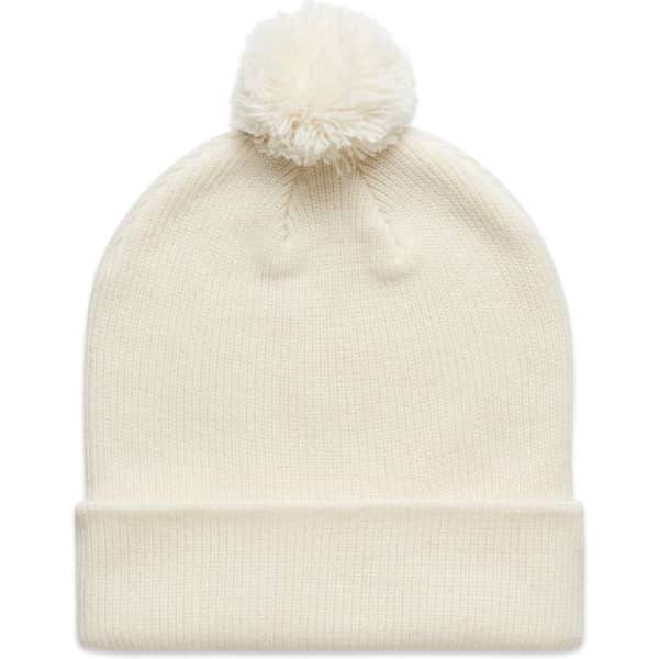 A cream Pom Pom Beanie with a fluffy pom pom on top and a folded cuff, featuring a logo on the side.