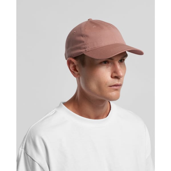 A pink cap with a rounded brim, modelled by a person wearing a white shirt, features a logo on the front.