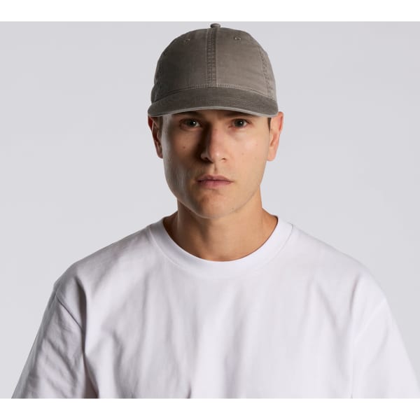 A grey cap with a rounded peak, featuring a logo and worn by a model in a plain white T-shirt.