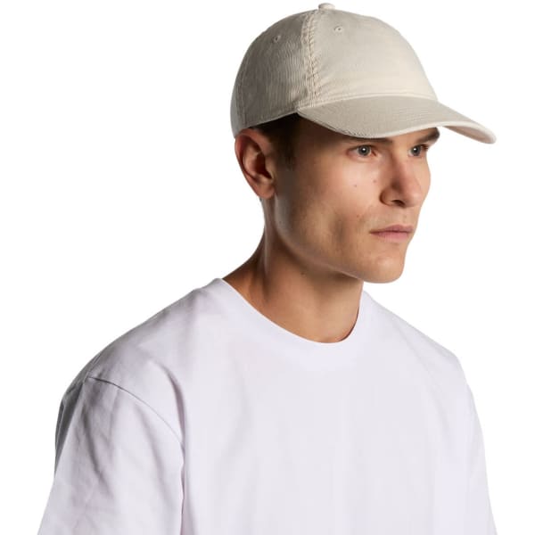 A light-coloured cap worn by a male model, featuring a simple design and a logo.
