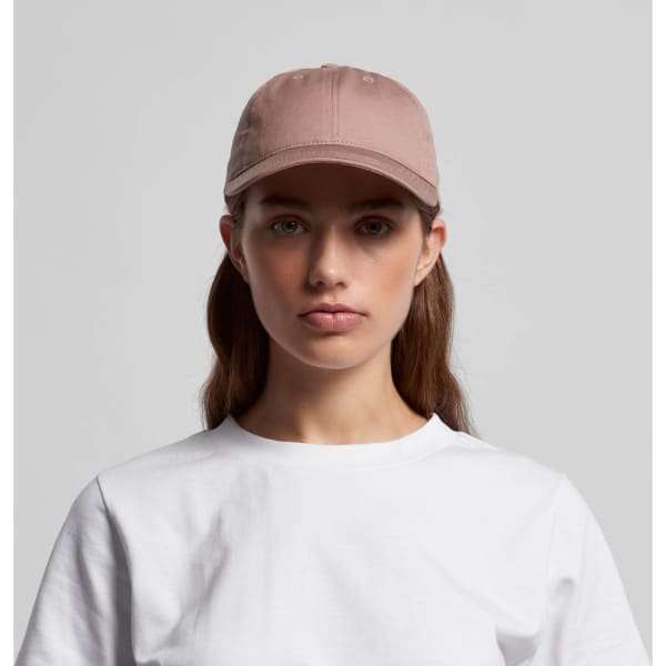 A light brown cap with a flat brim and a logo, worn by a woman in a white t-shirt.