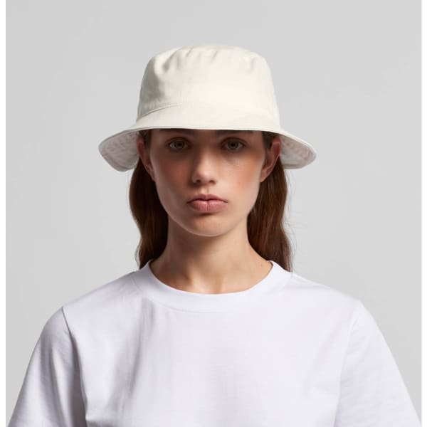 A white bucket hat with a soft brim, featuring a logo, worn by a model in a plain white T-shirt.