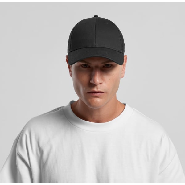 A black trucker cap with a structured front panel and mesh back, worn by a model in a white t-shirt.