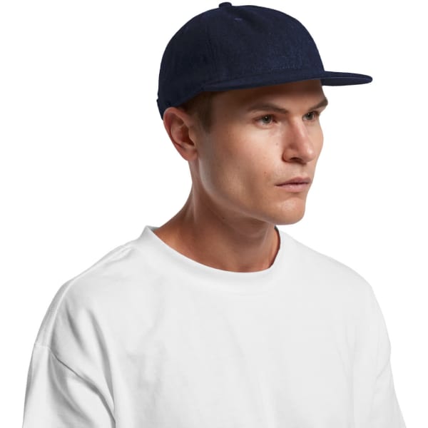 A navy Class Wool Cap with a flat brim, worn by a model in a white t-shirt. The cap features a logo.