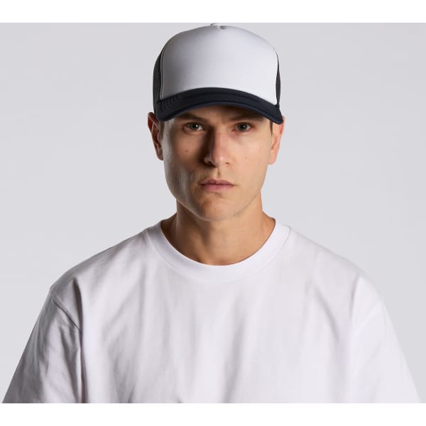 A two-tone trucker cap in white and black, featuring a logo on the front, worn by a model in a white t-shirt.