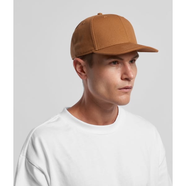 A brown Stock Canvas Cap is worn by a model with short hair, paired with a white t-shirt. The cap features a logo.