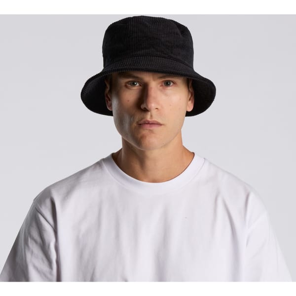 A black cord bucket hat worn by a model, paired with a plain white t-shirt. The hat features a branding logo.