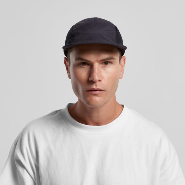 A black cap with a sleek design, featuring a logo and a person wearing a white sweatshirt.