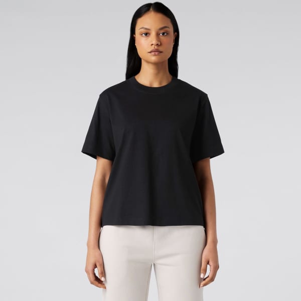 A black T-shirt with short sleeves and a relaxed fit, displayed on a model against a neutral background.