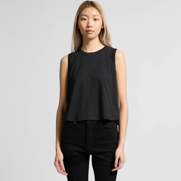 A black crop tank top with a relaxed fit, featuring a logo on the front. Model is wearing black jeans.