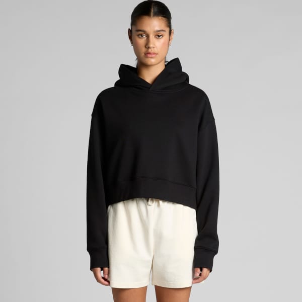 A black cropped hoodie with a hood, featuring long sleeves and a relaxed fit, worn with white shorts.