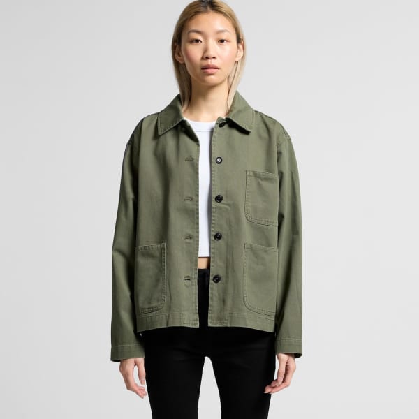 Olive green chore jacket with a relaxed fit, featuring front pockets and a collar. Model is wearing it with a white top.