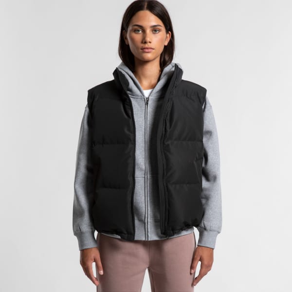 A black puffer vest worn over a grey hoodie, featuring a zip front and a logo on the chest.