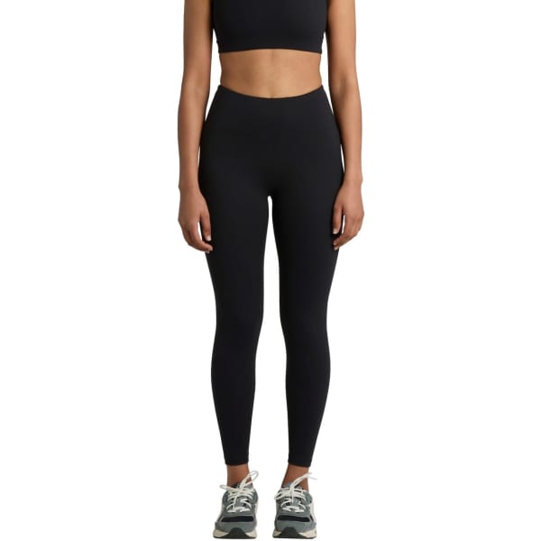 Black seamless leggings displayed on a model, paired with a matching crop top and athletic shoes. The image features branding.