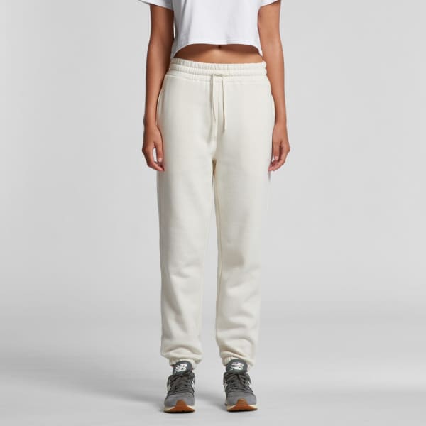 Cream-coloured track pants with a relaxed fit, featuring an elasticated waistband and a logo.