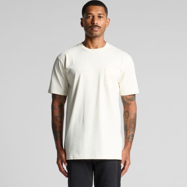 A man in a cream-coloured Classic Pocket Tee shirt, featuring a small pocket on the front.