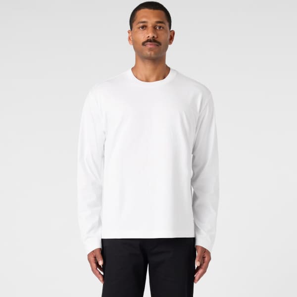 A long-sleeve white t-shirt worn by a model against a plain background. The shirt features a logo.