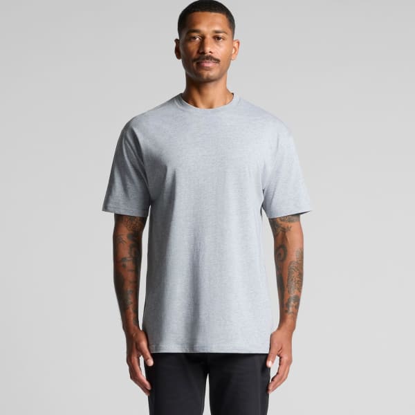 A grey t-shirt featuring short sleeves and a relaxed fit, displayed on a model with tattoos. Includes a logo.