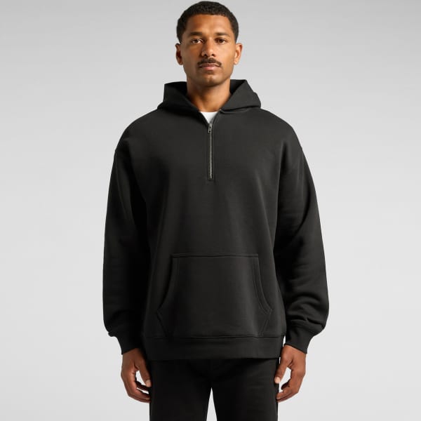 A relaxed half zip hoodie in black, featuring a front pocket and a hood, showcased on a model.