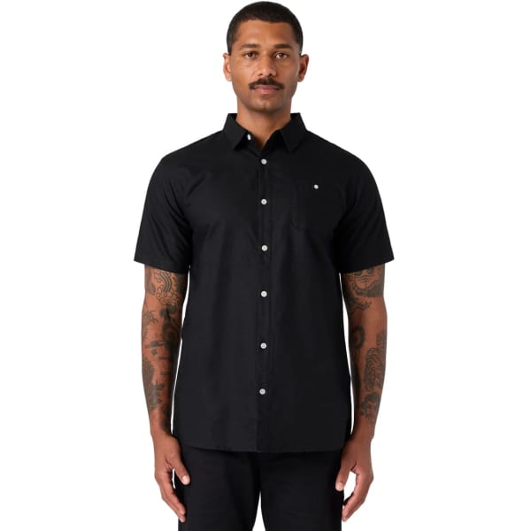 A black short-sleeve button-up shirt worn by a model, featuring a subtle logo.