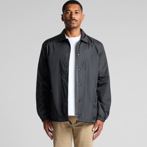 A black coach jacket is displayed on a model standing against a neutral background. The jacket features a branding logo.