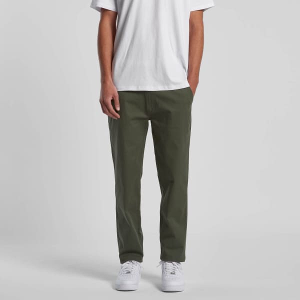 Straight pants in olive green, styled with a plain white t-shirt and white sneakers. The pants feature side pockets.