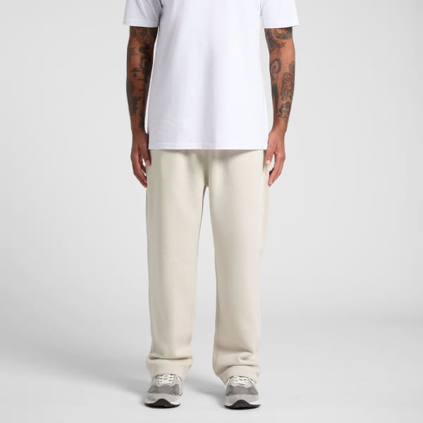 Cuffless track pants in a light cream colour, paired with a white t-shirt. A logo is visible on the garment.