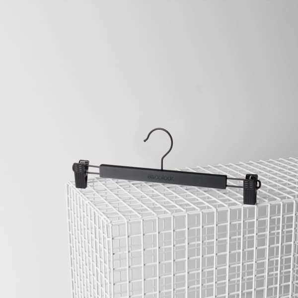 A black clip hanger designed for holding items, featuring adjustable clips and a hook for hanging.
