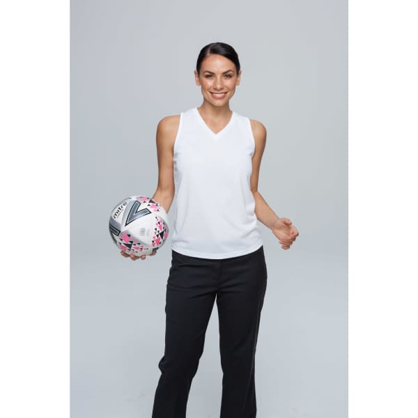 A woman wearing a white singlet holds a patterned netball, paired with black pants, against a light grey background.